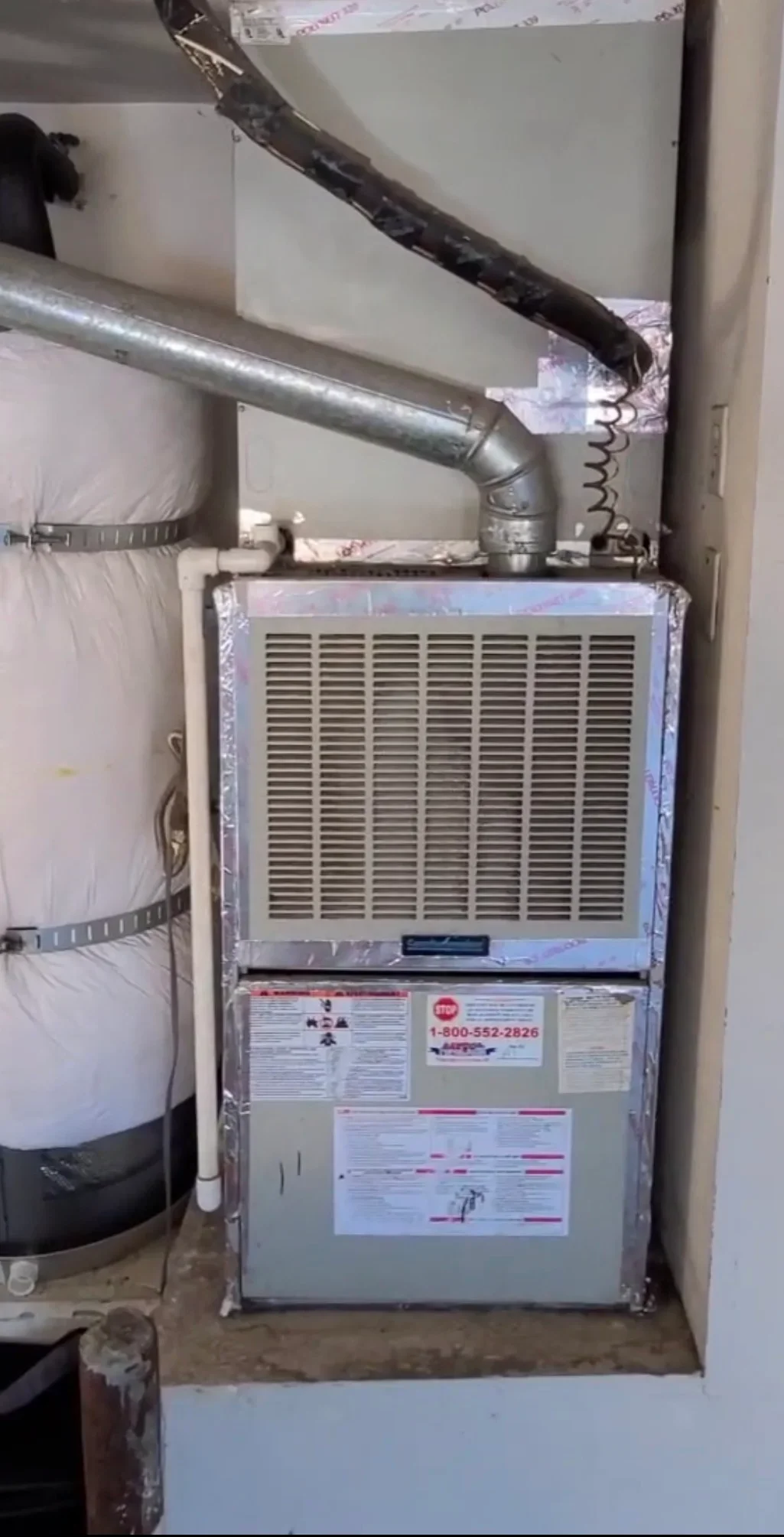 New furnace unit with metal ductwork, insulation, and return air connections in mechanical room