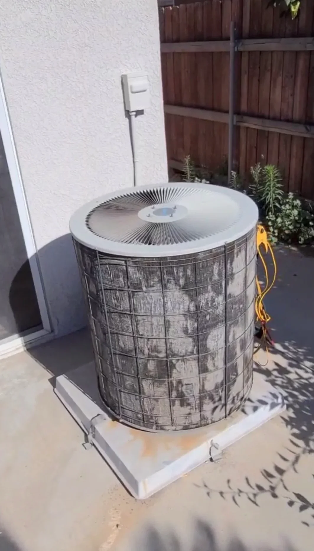 New AC condenser unit on concrete pad with electrical connections and disconnect switch installed